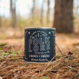 The Folklore Candle sitting on a bed of pine needles on the forest floor