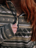 Girl with red hair wearing a patterned jacket with a focus on the zipper area.